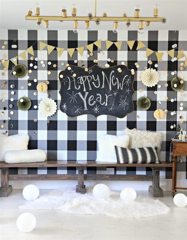 lesena klop, okrašena z blazinami za čahure, stena v črno -belem ozadju, fan deco in tabla s tablo iz skrilavca s srečnim novim letom