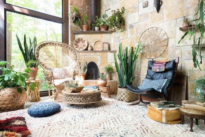 Berberski dekor dnevne sobe s kamnitimi stenami, orientalska mizica, množica zelenih rastlin, orientalski deko elementi