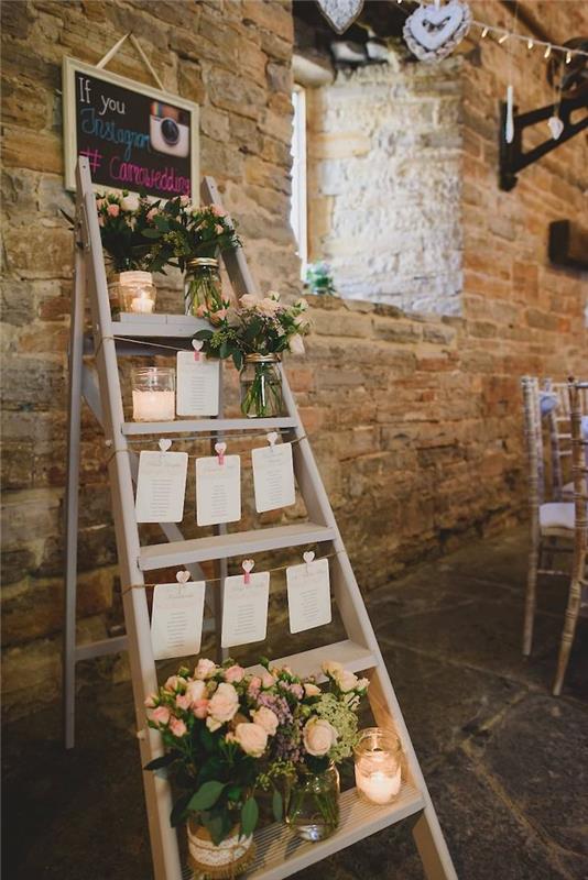 kmečki poročni dekor, lesena okrasna lestve z nalepkami za goste, ki visijo na vrvicah, cvetlični lonci z majhnimi šopki, prvotni načrt mize, kotiček za fotografije na instagramu