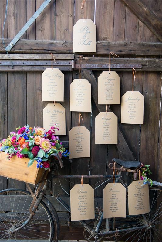 primer kmečke poročne dekoracije, kolo, starodobno kolo z etiketami za kolesa, leseni oanier s cvetjem v njem, lesena vrata