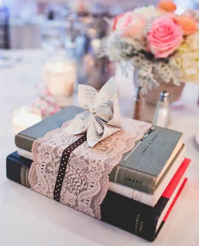 svežnjev knjig, zavitih v roza čipkast trak, šopek rož, svečniki, deko ideja za poroko