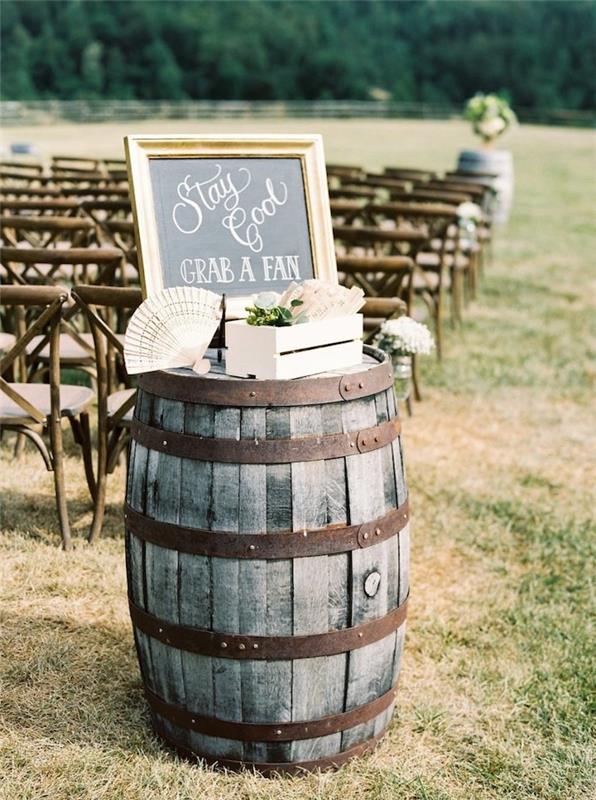 primer rustikalnega elegantnega poročnega dekorja, lesenega in kovinskega sode z lesenim zabojem, napolnjenim z ventilatorji za goste