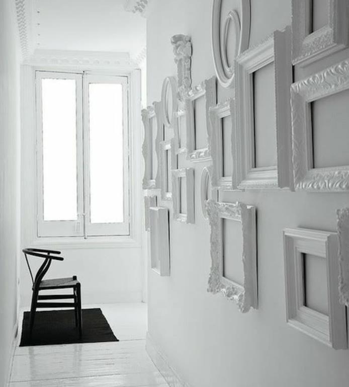 primer enobarvne dekoracije, sestavljen iz več okvirjev za fotografije na popolnoma beli steni, črne preproge in stolov, belega parketa, okna, ideja, kako okrasiti belo steno