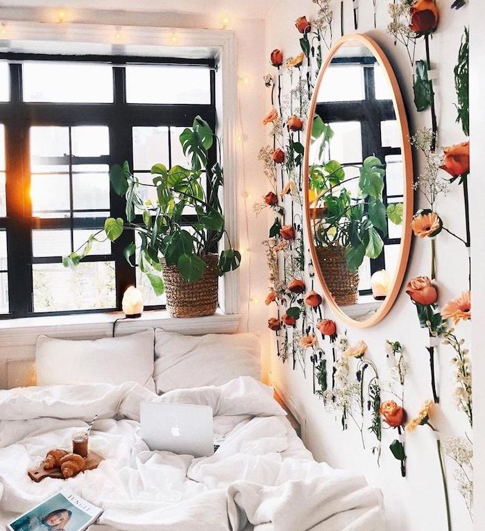 tropska rastlina na okenski polici in notranja zelena stena cvetnih vej okoli okroglega ogledala, romantična dekoracija spalnice