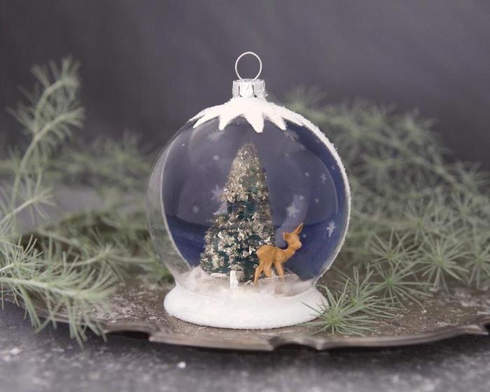 ročno izdelan božični okras, ki predstavlja polprosojno snežno kepo z barvo snežnega učinka, z božičnimi figuricami po vsem svetu