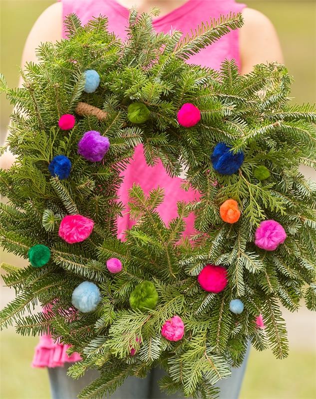 Kalėdinis vainikas pasigaminti natūralių eglių šakų ir įvairaus dydžio spalvingų pomponų
