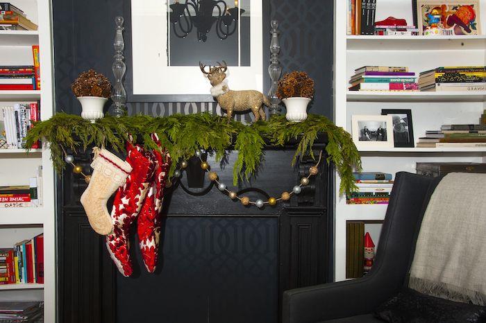 Çorap ve yeşil ve sahte çelenklerle Noel şöminesi dekoru
