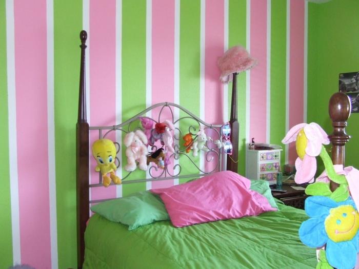 stene z navpičnimi črtami v zeleni in roza barvi, lesena in kovinska vzglavja, polnjene živali in cvetje, moderna spalnica, dekor za najstnice