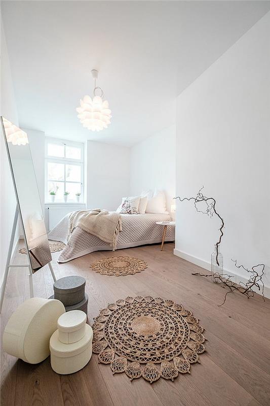 medinės lentos grindys, „macrame“ kilimas, didelis stačiakampis veidrodis, balti sienų dažai, miegamojo išdėstymas