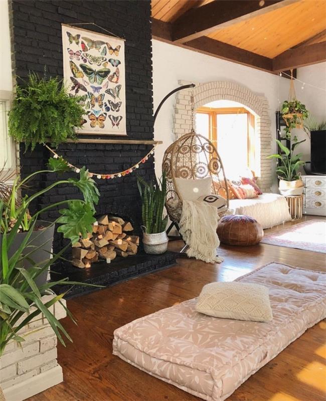 rotango svetainės dizainas su juodų plytų sienų sekcija ir mediniu parketu, bohemiško prašmatnaus stiliaus kambario apdaila augalais