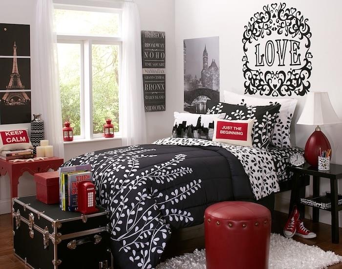 rdeča in črna deko, belo in črno posteljnina, majhni rdeči poudarki, ideja grafične stenske nalepke, bela preproga, konec postelje v črni skrinji