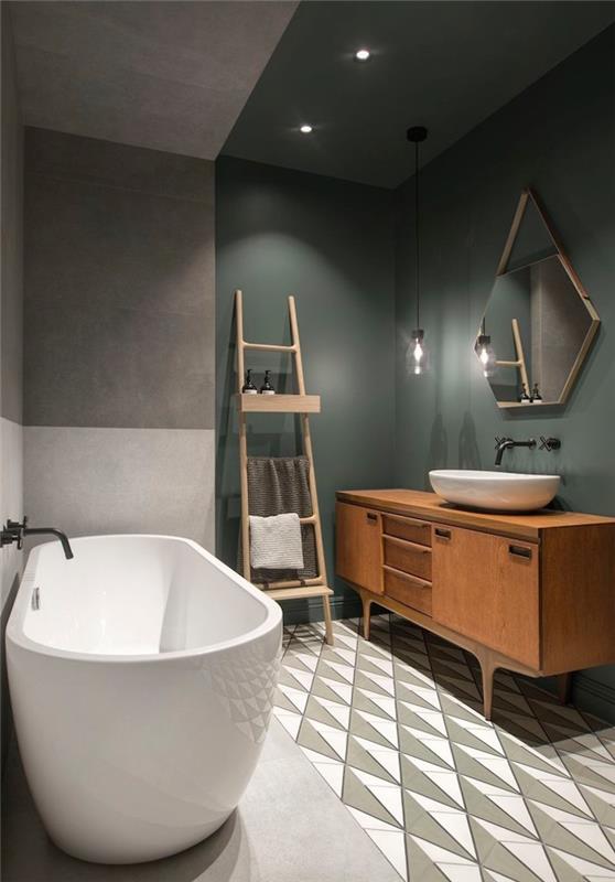 Skandinavska kopalnica z retro leseno omarico za umivalnik s keramičnimi in cementnimi tlemi ter dvobarvnimi kaki verdigris in voskanimi betonskimi stenami z oblikovalsko kadjo