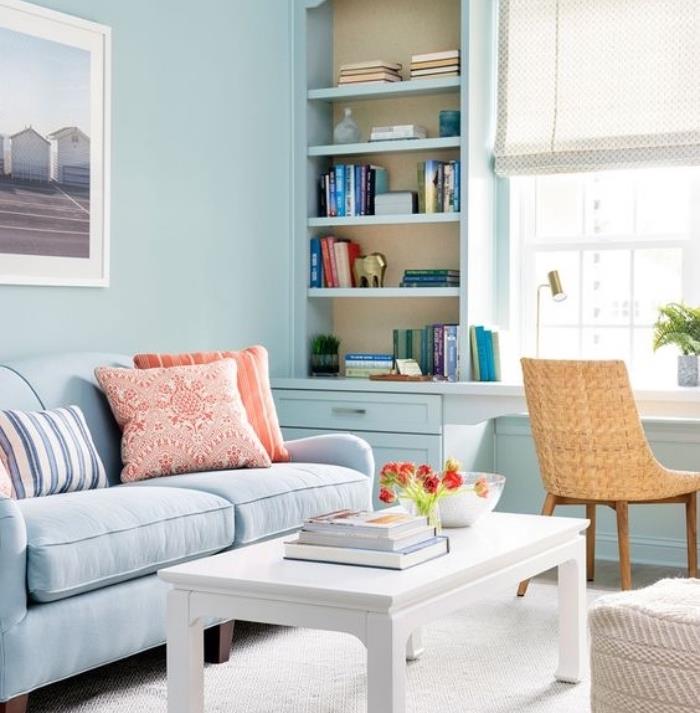 küçük dokunuşlarla tanıtılan beyaz ve bej oturma odası, beyaz halı ve sehpa, bej sandalye, kanepe ve mavi duvar