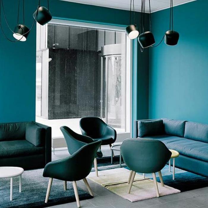 anties mėlyna siena, mėlynos kėdės, stačiakampės mėlynos sofos, pramoninio stiliaus lempos