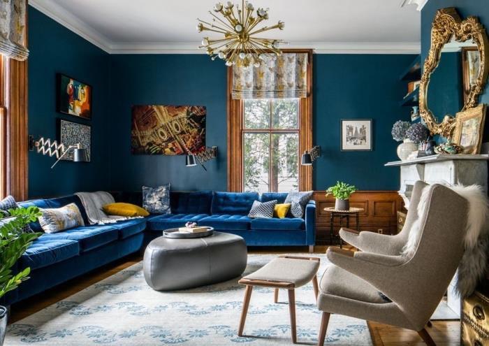lacivert kadife kanepe ve petrol mavisi duvarların birlikteliği ile zarif bir oturma odasında benimsenen ton-on-ton trendi