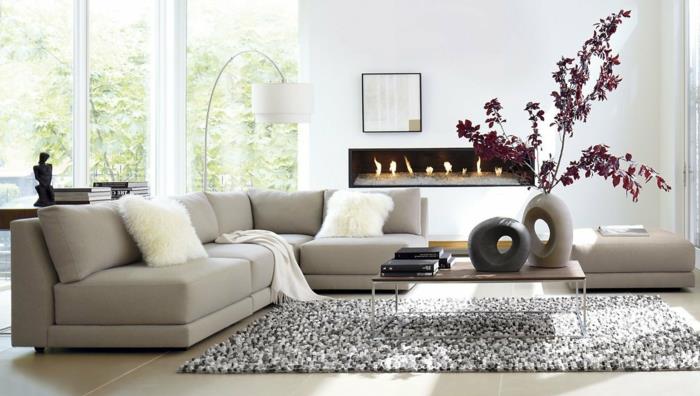 šiuolaikiškas svetainės dekoras, pilka kampinė sofa, medinis ir geležinis stalas, minkštas kilimas