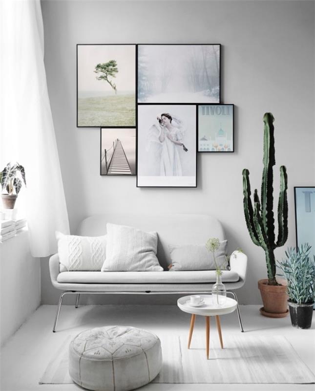 sivo -beli dekor dnevne sobe, beli kavč, otomanska in siva preproga, skandinavska minimalistična klubska mizica, stenska dekoracija okvirjev, slikanje in fotografije, kaktusi in druge rastline
