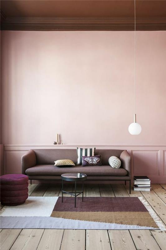 pilkas svetainės dekoras, rožiniai sienų dažai, skandinaviško stiliaus pilka sofa, apvali pakabinama lempa