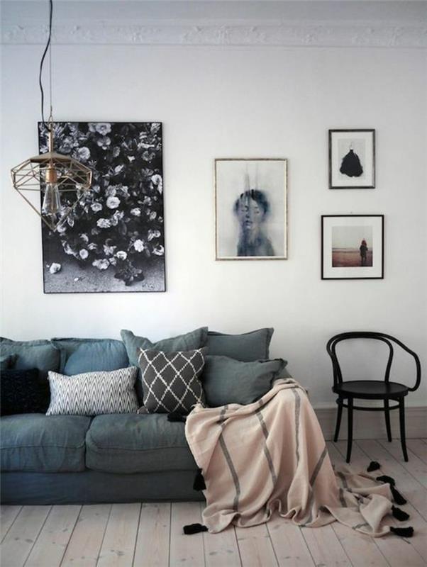 pilkas svetainės dekoras, narvo lempa, senovinė juoda kėdė, rožinė pledas su juodais pakraščiais