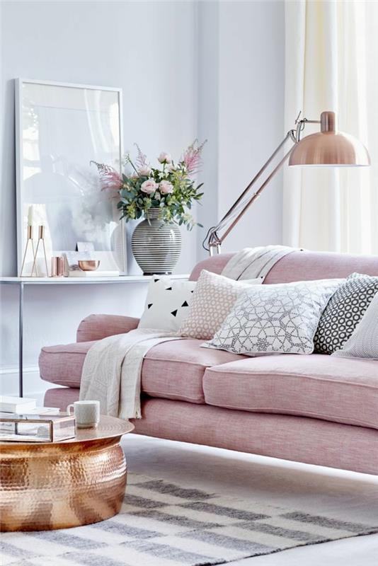 pilkas svetainės dekoras, minkšta rožinė sofa, varinis stalas, varinė grindų lempa, dekoratyvinės pagalvėlės