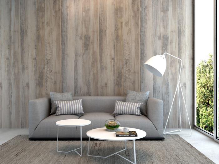 šiuolaikiška gyvenamojo kambario sienų dekoravimo idėja su plačiomis pilkos spalvos medinėmis dailylentėmis, šiuolaikiškas šviesiai pilkos spalvos svetainės sofos modelis
