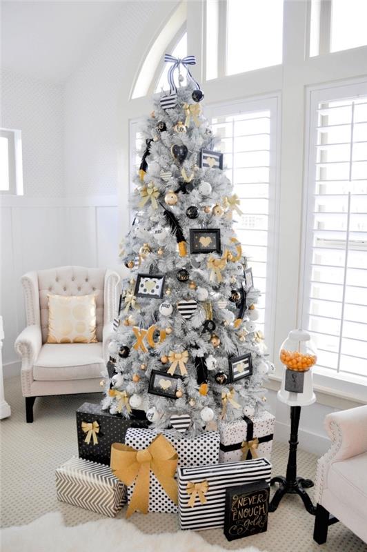 Katedral tavanlı beyaz bir oturma odasında turuncu ve siyahla süslenmiş beyaz dalları olan orijinal Noel ağacı modeli, şık dekor fikri