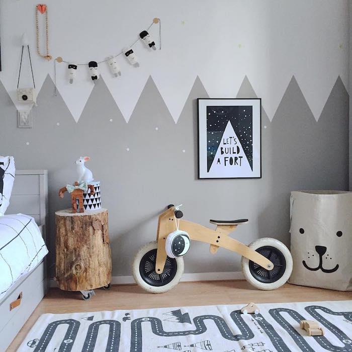 Skandinaviškos temos kūdikio kambario dekoravimo šablonas su balta ir pilka siena bei skandinaviškais mediniais baldais