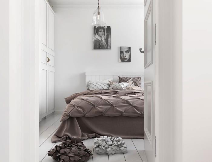 İskandinav yatak odası modeli, kahverengi nevresim, beyaz yatak, beyaz parke, grafik portreler duvar dekorasyonu