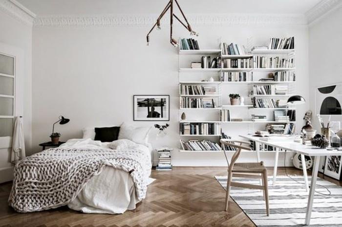 Skandinaviškas dekoras, skirtas šviesiam ir erdviam miegamajam su baltais viršeliais, baltos bibliotekos darbo kampas su skandinaviška kėde ir baltu stalu