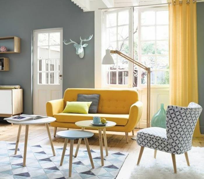 İskandinav oturma odası dekoru, sarı perde ve kanepe, sehpa ve mavi geometrik desenli halı, beyaz kürk halı, hafif parke