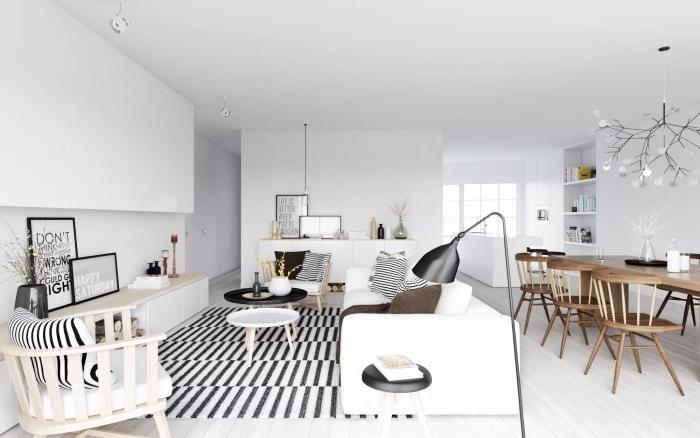 Yemek odasına açık İskandinav oturma odası düzeni, siyah beyaz halı, beyaz kanepe, ahşap sandalyeler, açık renkli parke, yemek odası sandalyeleri ve ahşap masa