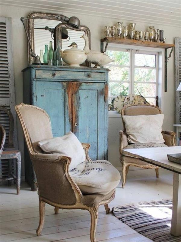 eleganten podeželski dekor, leseni in sivi stoli iz tkanine, patinirana modra omara, dekor ogledal, miza iz masivnega lesa, pobeljeno parket