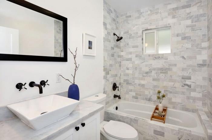 zamisel, kako urediti majhno belo kopalnico s sivo -belo kadjo z ogledalom in črnimi pipami