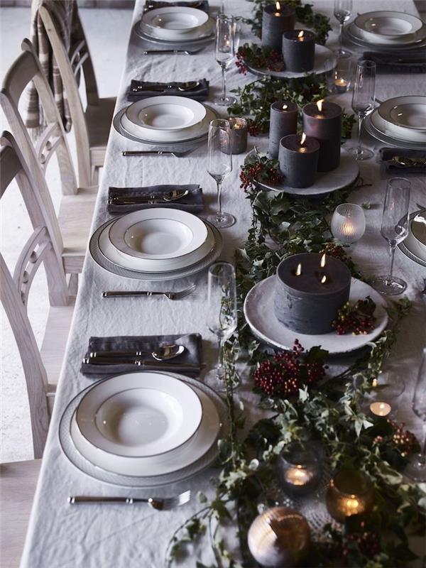 beyaz bir masa örtüsü ve yeşil dut süslemeleri ile deco aziz arifesi masası tabaklarda büyük mumlar