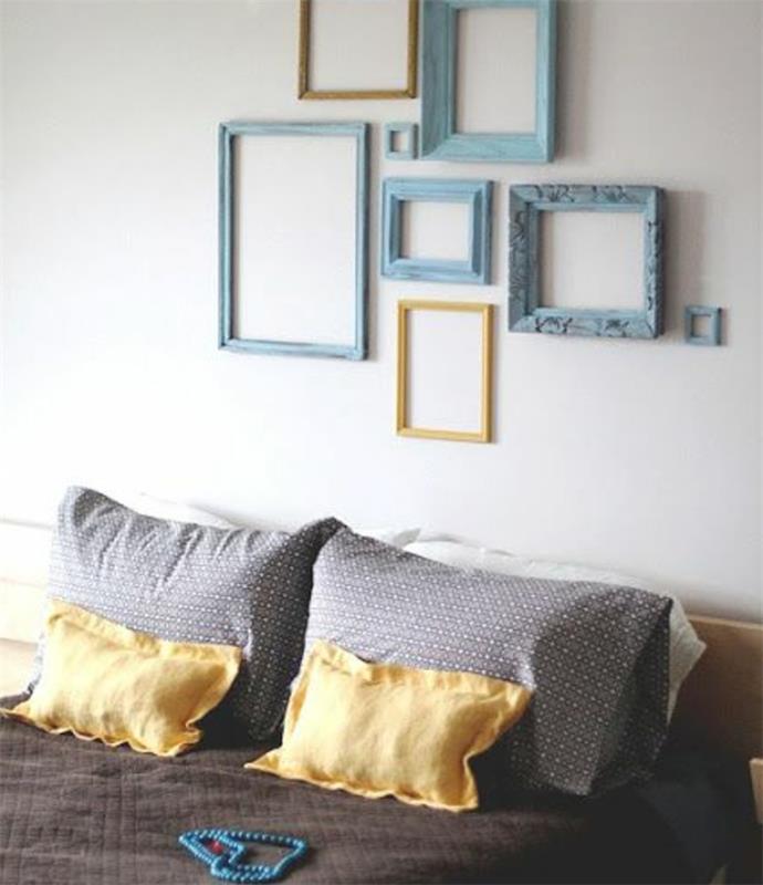 zamisel, kako okrasiti oblikovalsko spalnico, steno iz modrih in rumenih okvirjev, leseno posteljo, sivo in rumeno posteljno prevleko