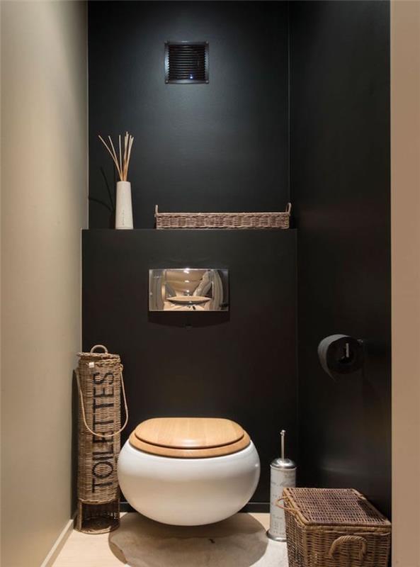ideja treznega in zen dekorja stranišča s črnimi in bež stenami ter okroglim visečim straniščem