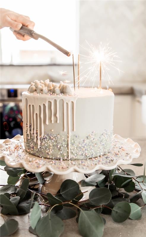 pravljična torta pinata s tekočo belo čokoladno glazuro, okrašeno z bisernimi sladkornimi biseri, okrašena z užitnim prahom, sladkornimi biseri in marshmallowom