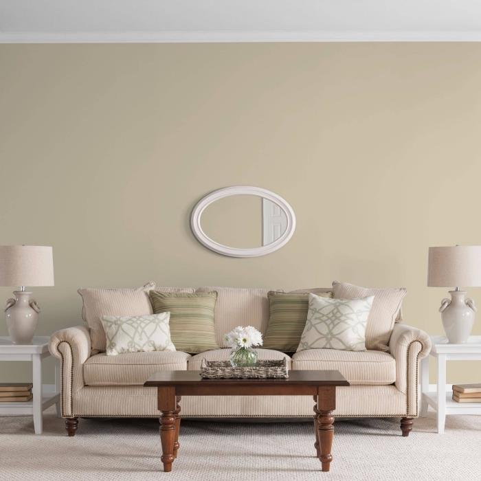bež barva v dnevni sobi v vintage stilu, opremljena z belim in temno rjavim lesenim pohištvom ter dodatki v pastelnih odtenkih