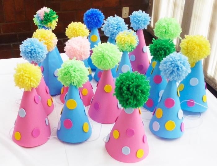 Bir çocuğun doğum günü veya partisi için ev dekorasyonu fikri, renkli ponponlu pembe ve mavi şapkalar