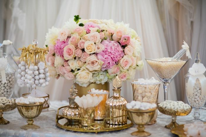 poročna sladkarija, beli sladkorni mandlji, cvetlični osrednji del, šopek rož, ozadje bele zavese, beli prti, steklene posode in zlate posode