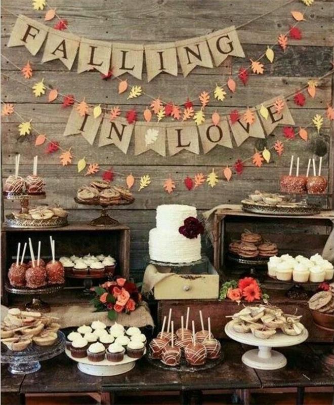şeker çubuğu dekorasyonu, kekler, kurabiye kurabiyeleri, turtalar, çikolatalı elmalar, iki katlı pasta, kağıt yaprak çelenk ve ilginç kumaş çelenk, ahşap masa, rustik eski düğün