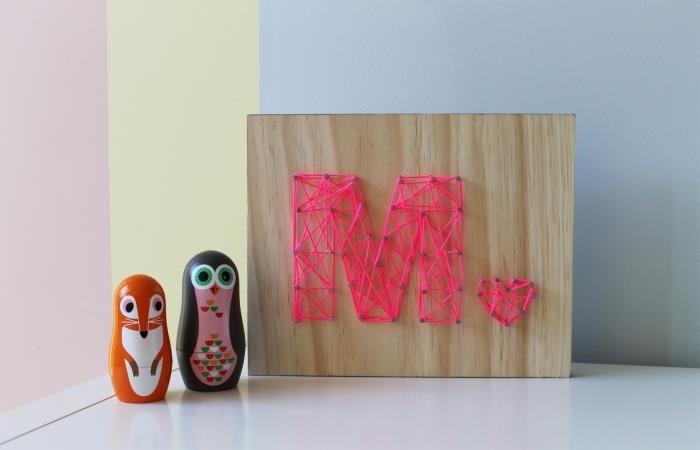vaikų kambario išdėstymo pavyzdys su aksesuarais ir rankų darbo daiktais, medinės plokštės su M raide vieloje ir vinimis modelis