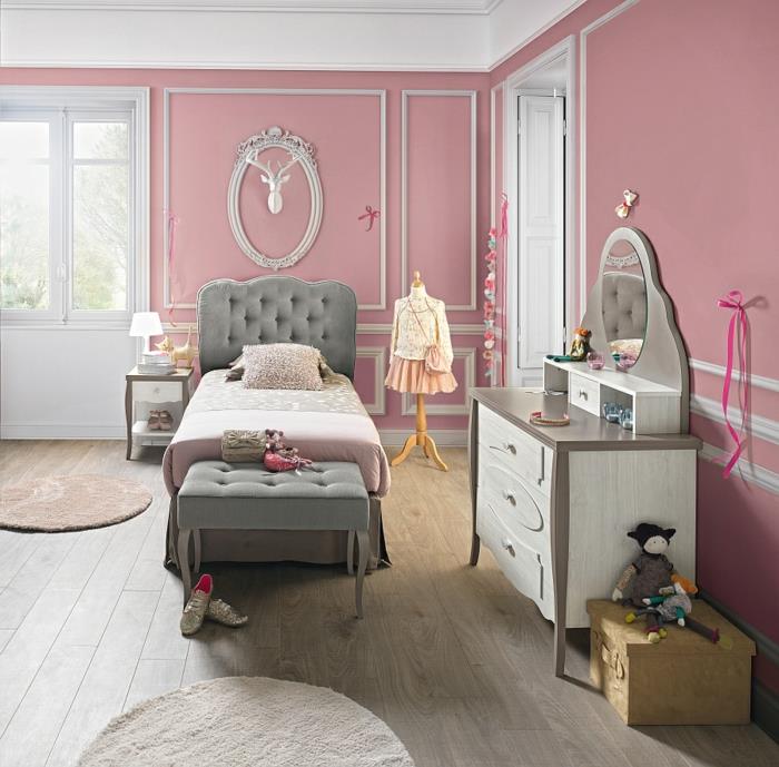 dekoracija spalnice za dekleta, starinska bela in rjava komoda, siva postelja, lesena tla, igrače, otroška soba, ki se nahaja