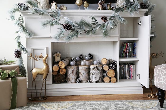 baldų apdaila netikras židinys iš baltos medienos su laikymo tipo komoda kaip televizoriaus stovas su skandinavišku kalėdiniu dekoru su mediniais rąstais