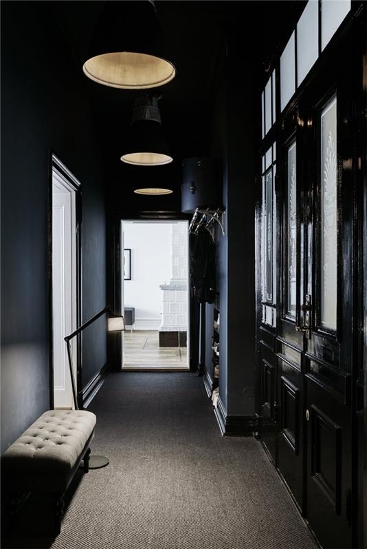 Deco ozek hodnik v slogu Haussmann z mat črno pobarvanimi stenami, ki gleda na belo dnevno sobo