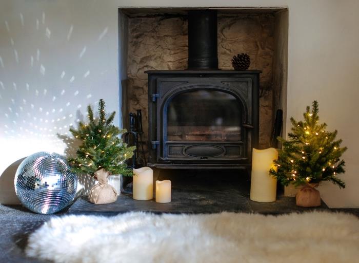Beyaz ve ahşap bir oturma odasında İskandinav tarzı doğa Noel deco fikri, hafif çelenkle süslenmiş mini ağaç modelleri