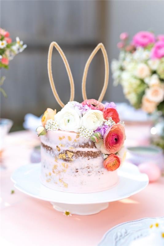 precej gola torta, prekrita s svetlo plastjo rožnate maslačke in okrašena s cvetjem, nadloga za torto iz zajčjih ušes