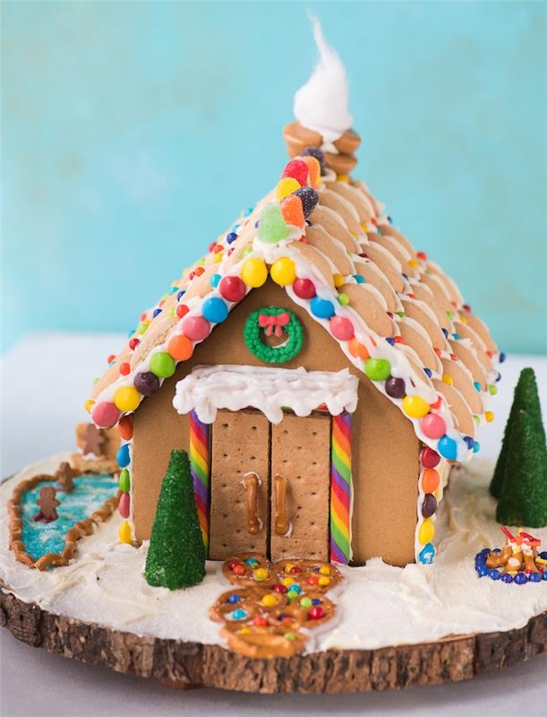 gurme Noel dekorasyonu, ahşap bir kütük üzerinde kurabiyeler, renkli şekerler, simit ve diğerleri süslemeli orijinal ev yapımı zencefilli Noel tatlısı
