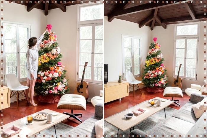 farklı renklerde çiçek çelenklerle süslenmiş bir Noel ağacı örneği, çiçek ağacı ile beyaz ve ahşap bir oturma odasında rahat bir atmosfer