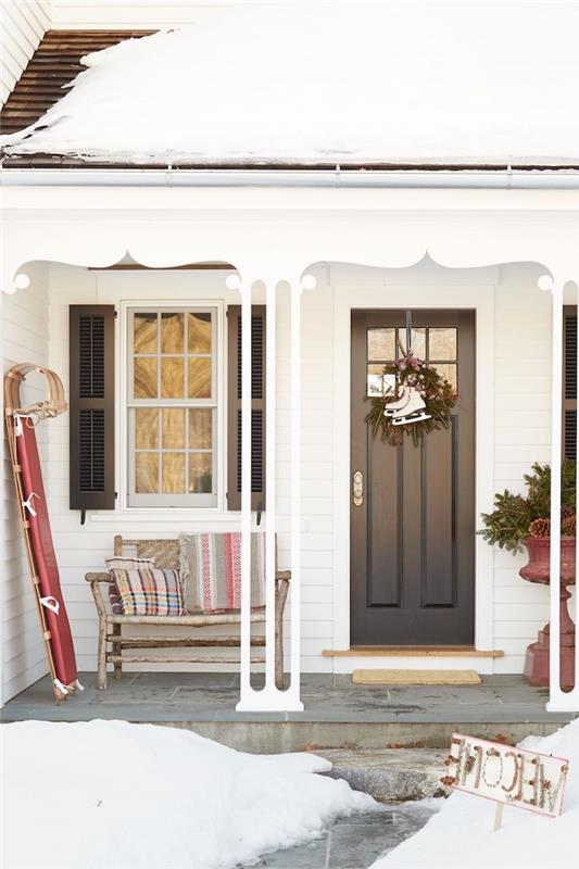 Kapıda asılı patineler, duvara bağlı bir kızak ve ahşap bir bank ile ucuz Noel dekorasyonu